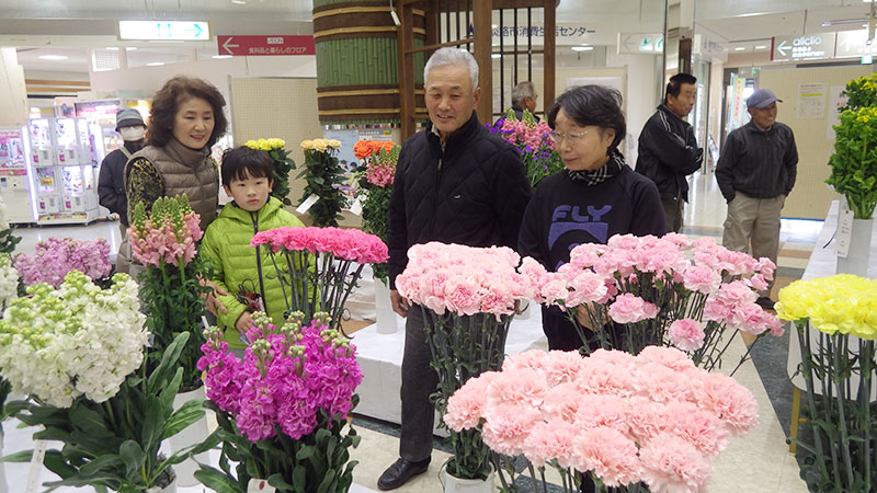 2018年2月のトピックス「花の展示を楽しむ買い物客ら」